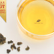Load image into Gallery viewer, Hwa Gung Tea Eternity Series Reserved Hwa Gung Alpine Oolong Tea tea soup and ball shaped loose tea leaves