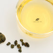 Load image into Gallery viewer, Hwa Gung Tea Legends Series Selected AliShan Alpine Oolong Tea tea soup and ball shaped loose tea leaves